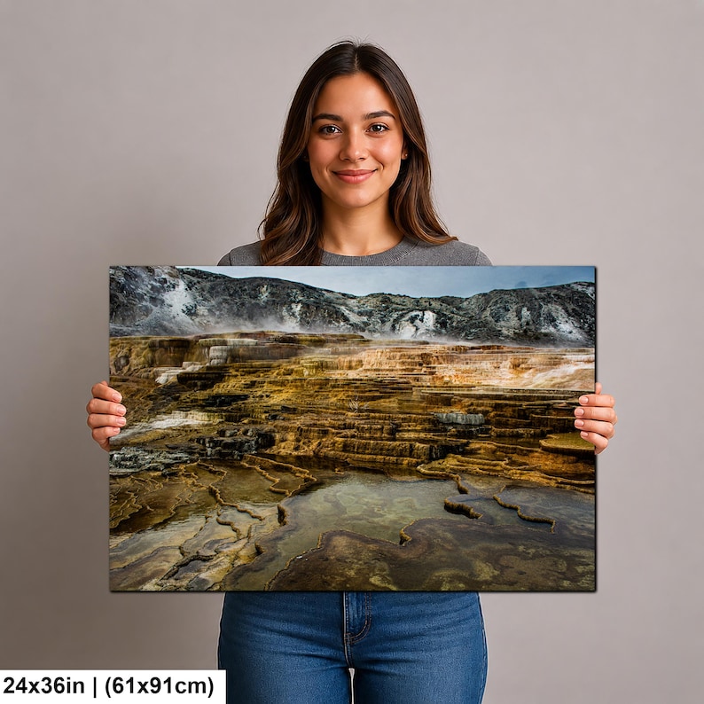 K&ouml;nnte beinhalten: Ein rechteckiger Wandkunstdruck in der Gr&ouml;&szlig;e 61 x 91 cm, der eine Landschaftsaufnahme von geothermischen Terrassen mit geschichteten, goldbraunen Mineralablagerungen, Wasserbecken und aufsteigendem Dampf vor felsigen H&uuml;geln zeigt.