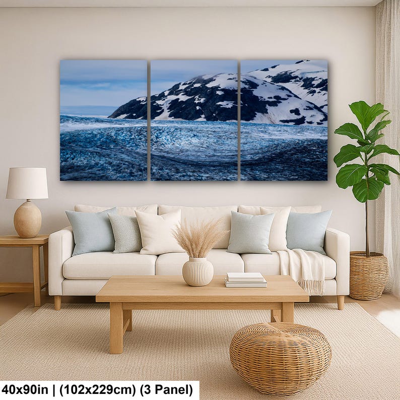 May include: A three-panel wall art set depicting a snowy mountain landscape with a dark, textured glacier in the foreground. The artwork measures 40x90 inches in total. The scene features deep blue and white tones across the three canvas sections.