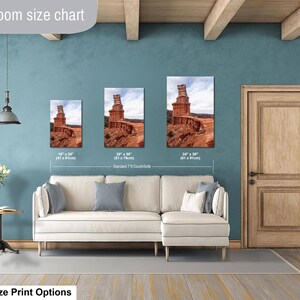 May include: A living room size chart displaying three rectangular wall art prints of a red rock desert landscape. The prints are labeled with dimensions of 16 inches by 24 inches, 20 inches by 30 inches, and 24 inches by 36 inches above a couch.