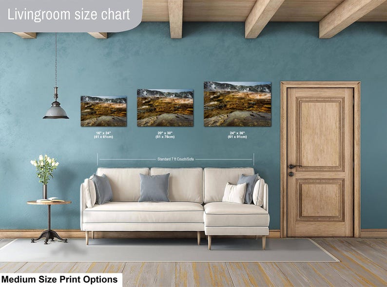 K&ouml;nnte beinhalten: Eine Gr&ouml;&szlig;entabelle f&uuml;r Wohnzimmer zeigt drei Landschafts-Wandbilder &uuml;ber einem cremefarbenen Ecksofa. Die Drucke zeigen eine geothermische Landschaft und sind mit den Ma&szlig;en 41 x 61 cm, 51 x 76 cm und 61 x 91 cm beschriftet.