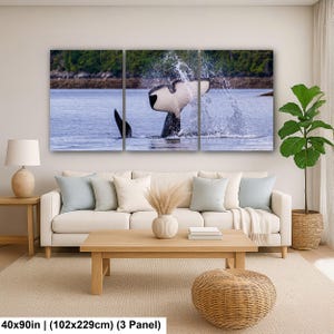 May include: A three-panel wall art set depicting an orca whale tail splashing in blue water against a green forest background. The artwork measures 40x90 inches in total. The scene captures the black and white tail fluke emerging from the ocean.