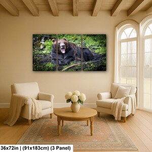 May include: A three-panel wall art set featuring a brown bear with its mouth open, resting on a grassy, mossy forest floor. The artwork is labeled with dimensions of 36x72 inches, indicating the total size of the three-panel display.