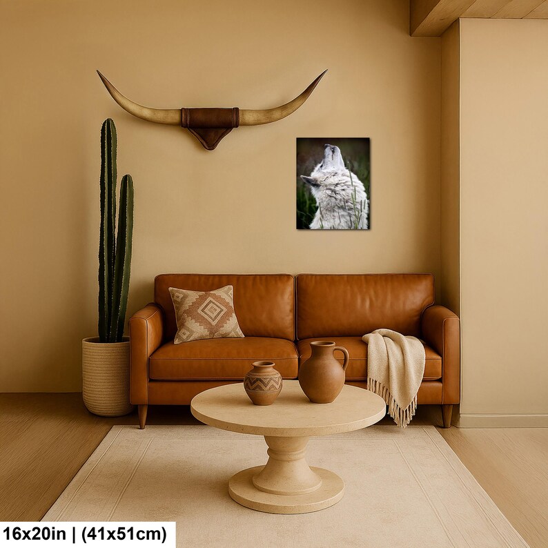 Pu&ograve; includere: Una stampa artistica rettangolare da parete raffigurante un lupo bianco che ulula, esposta sopra un divano in pelle marrone. La stampa misura 41 cm per 51 cm. La scena include un cactus alto, un cuscino decorativo e due vasi in ceramica.