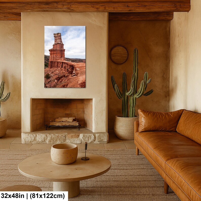 May include: A rectangular wall art print featuring a tall, layered red rock formation set against a cloudy sky. The landscape photograph displays textured canyon cliffs in shades of orange and brown. The print measures 32 inches by 122 inches.