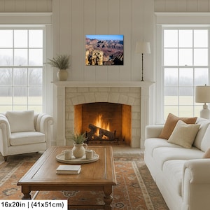 May include: A rectangular wall art print measuring 16 inches by 20 inches, featuring a landscape photograph of the Grand Canyon with deep brown rock formations, shadows, and a bright blue sky, displayed above a stone fireplace in a living room.