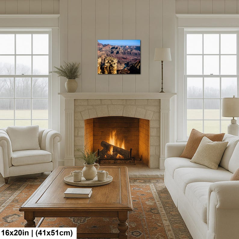 May include: A rectangular wall art print measuring 16 inches by 20 inches, featuring a landscape photograph of the Grand Canyon with deep brown rock formations, shadows, and a bright blue sky, displayed above a stone fireplace in a living room.