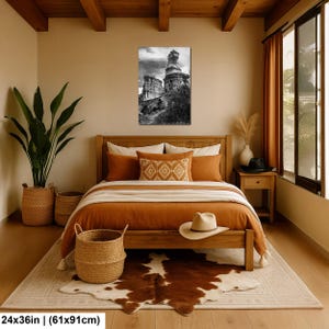 May include: A rectangular wall art print measuring 24 by 36 inches, featuring a black and white photograph of ancient stone ruins under a cloudy sky. The artwork is displayed in a vertical orientation, showcasing weathered rock structures and foliage.