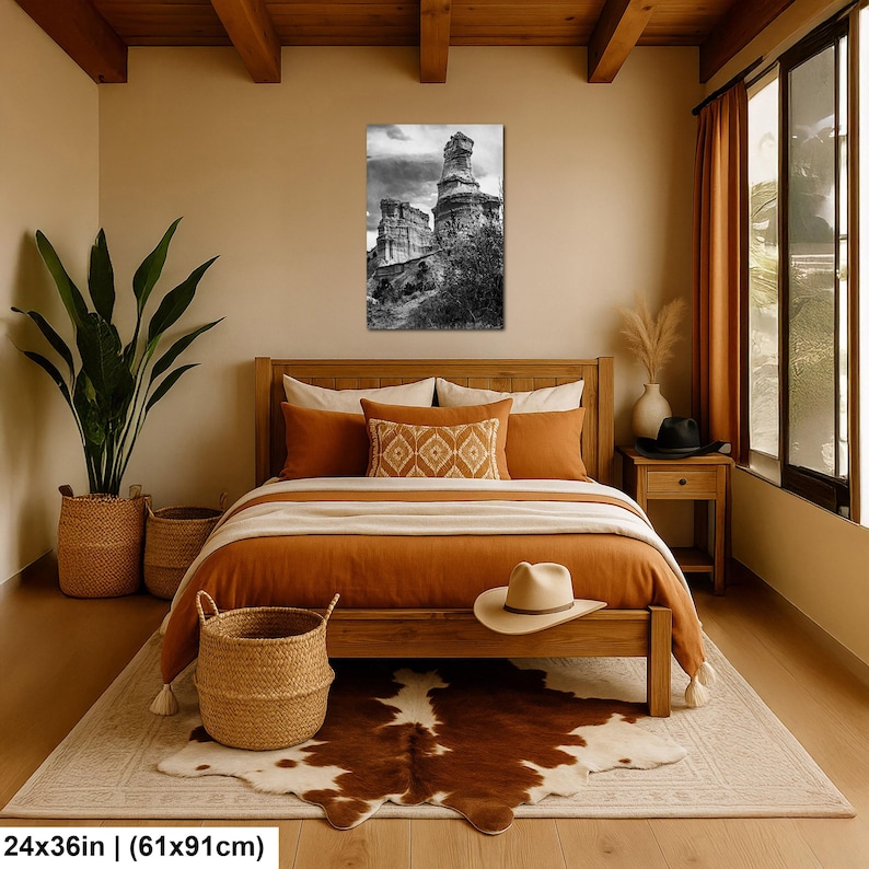 May include: A rectangular wall art print measuring 24 by 36 inches, featuring a black and white photograph of ancient stone ruins under a cloudy sky. The artwork is displayed in a vertical orientation, showcasing weathered rock structures and foliage.
