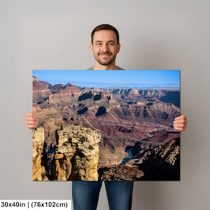 May include: A rectangular wall art print measuring 30 by 40 inches, featuring a high-resolution landscape photograph of the Grand Canyon. The image displays layered rock formations in shades of red, brown, and tan, with a blue river below.