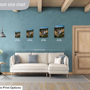 May include: A living room size chart displaying four rectangular wall art prints of a waterfall landscape above a cream-colored sectional sofa. The prints are labeled with dimensions ranging from 8 by 10 inches to 16 by 20 inches for scale.
