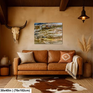 May include: A rectangular wall art print depicting a terraced landscape with flowing water, mounted above a brown leather sofa. The print measures 30 inches by 40 inches. The scene features layered rock formations in shades of brown, tan, and white.