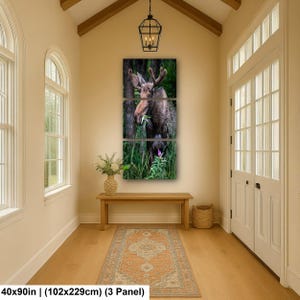 May include: A three-panel wall art set featuring a brown moose standing in a lush green forest, eating foliage. The artwork is displayed in a vertical arrangement. The text at the bottom indicates dimensions of 40x90 inches for the 3-panel set.