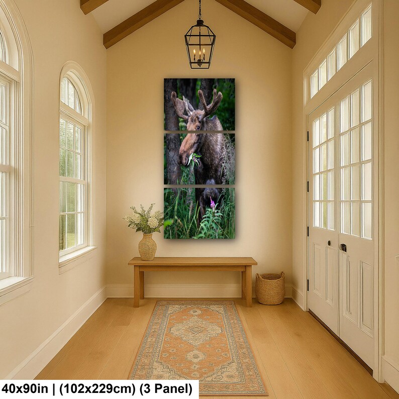May include: A three-panel wall art set featuring a brown moose standing in a lush green forest, eating foliage. The artwork is displayed in a vertical arrangement. The text at the bottom indicates dimensions of 40x90 inches for the 3-panel set.
