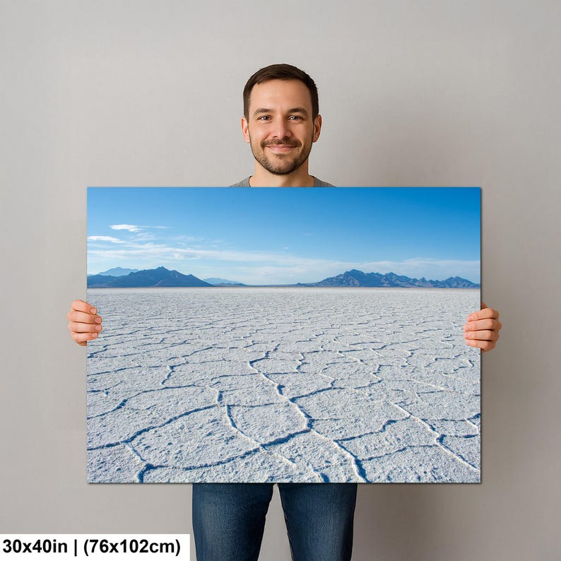 May include: A rectangular wall art print measuring 30 by 40 inches, featuring a landscape photograph of the Bonneville Salt Flats with a white, cracked salt crust surface, distant blue mountains, and a clear blue sky with light clouds.