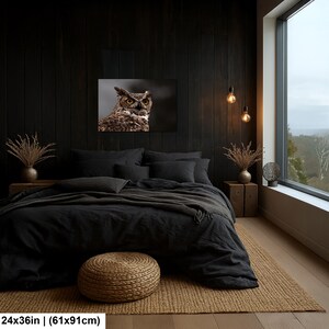 May include: A rectangular wall art print featuring a detailed portrait of a great horned owl with piercing yellow eyes and brown mottled feathers, measuring 24 inches by 36 inches, displayed above a bed in a dark-themed bedroom setting.