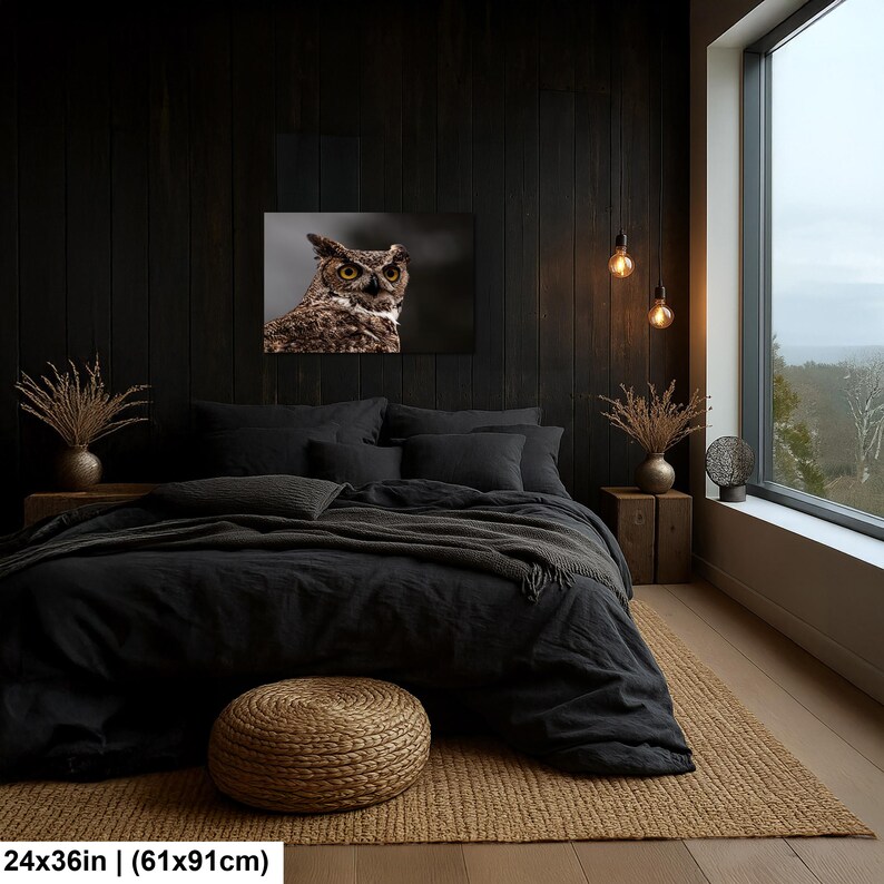 May include: A rectangular wall art print featuring a detailed portrait of a great horned owl with piercing yellow eyes and brown mottled feathers, measuring 24 inches by 36 inches, displayed above a bed in a dark-themed bedroom setting.