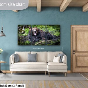 May include: A three-panel wall art set featuring a brown bear resting in a grassy field, displayed above a cream-colored sectional sofa. The artwork measures 36 by 72 inches and is positioned to show scale relative to a standard 7-foot couch.