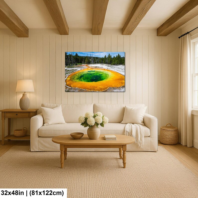 May include: A rectangular wall art print featuring a vibrant geothermal pool with a deep green center surrounded by bright orange and yellow mineral deposits, set against a backdrop of dark green pine trees and a clear blue sky, measuring 32x48 inches.