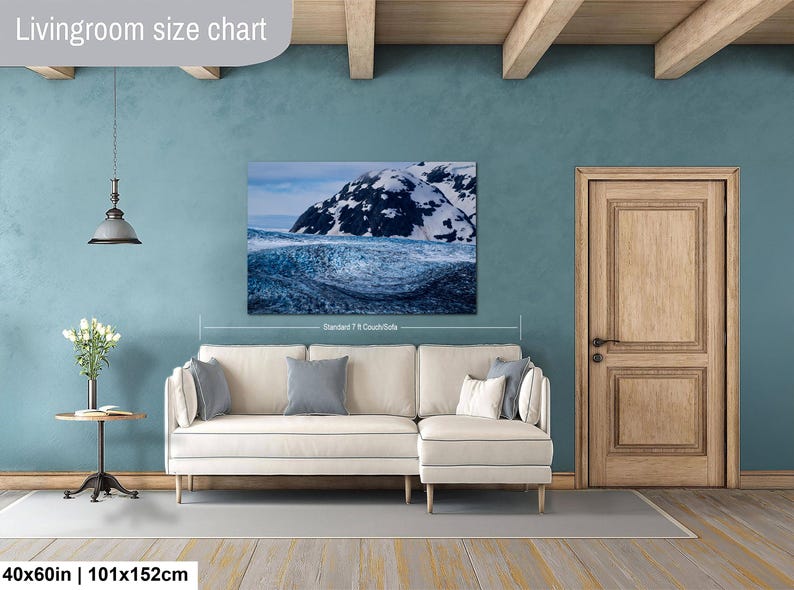 May include: A rectangular wall art print featuring a snowy mountain landscape above a dark blue ocean wave. The print is labeled 40x60in and 101x152cm, with text reading Livingroom size chart and Standard 7 ft Couch/Sofa visible on the display.