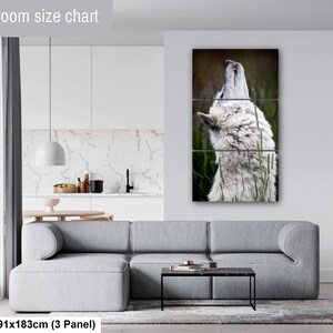 Pu&ograve; includere: Un set di arte da parete a tre pannelli raffigurante un lupo bianco che ulula, esposto sopra un divano grigio. L'opera misura 91 per 183 cm. Il testo Livingroom size chart &egrave; visibile nell'angolo in alto a sinistra dell'immagine.