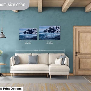 May include: Two rectangular wall art prints featuring a snowy mountain landscape above a dark blue ocean wave. The prints are labeled with dimensions of 20 inches by 30 inches and 24 inches by 36 inches, displayed above a cream-colored sectional sofa.