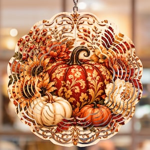 May include: A circular hanging wind spinner featuring a detailed autumn-themed design. The artwork displays a large central orange pumpkin with gold filigree patterns, flanked by white and orange pumpkins, sunflowers, and foliage in warm tones.
