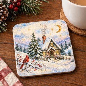 May include: A square coaster featuring a winter scene with a snow-covered cottage, a tall pine tree, and a red cardinal perched on a branch with berries. The illustration includes a crescent moon, stars, and smoke rising from the chimney.