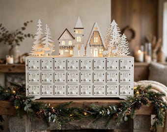 Calendario de Adviento de madera blanca con 24 cajones, silueta de pueblo navideño, decoración para la cuenta regresiva navideña.
