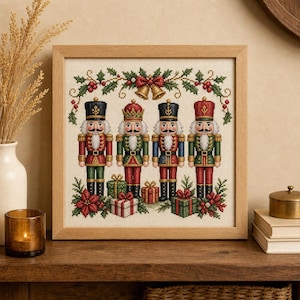 Puede incluir: Un bordado en punto de cruz enmarcado que presenta cuatro figuras de cascanueces con uniformes rojos, verdes, azules y dorados. El diseño incluye una guirnalda de acebo con campanas doradas arriba y regalos envueltos con flores de pascua.