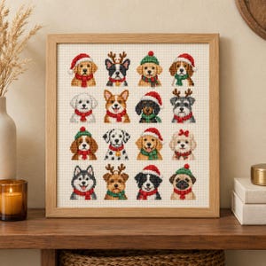 Puede incluir: Un bordado en punto de cruz enmarcado que presenta una cuadrícula de dieciséis razas de perros diferentes. Cada perro aparece con accesorios festivos como gorros de Papá Noel rojos, gorros de invierno verdes, astas de reno y bufandas.
