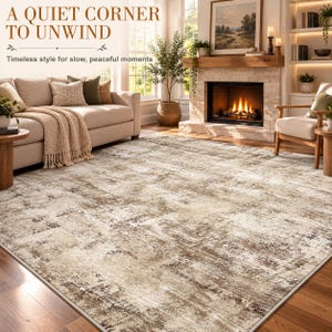 May include: A large rectangular area rug featuring a distressed, mottled pattern in shades of beige, cream, and dark brown. The rug covers a wooden floor in a living room with a beige sofa, a fireplace, and a potted plant.