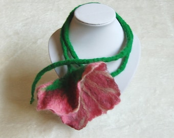 May include: A pink and white felt flower necklace with green felt leaves on a white mannequin.