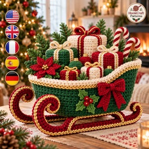 Puede incluir: Un trineo de Navidad de ganchillo en verde oscuro con patines rojos y borde dorado, decorado con un lazo rojo y acebo. El trineo está lleno de regalos de ganchillo en rojo, verde y crema, bastones de caramelo, ramas de pino y una flor de pascua.