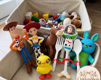 May include: A collection of plastic character figures including a cowboy, a cowgirl, a brown horse, a space ranger, a blue rabbit, a yellow chick, and a white spork character, all arranged inside a beige fabric storage bin with other toys.