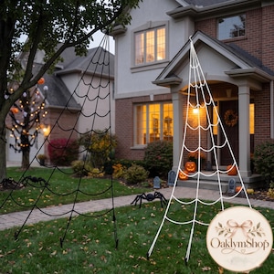 May include: Two large, triangular spider web decorations for outdoor display. One web is black and suspended from a tree branch, while the other is white and stands on the lawn. Both feature a classic radial web pattern with interconnected lines.