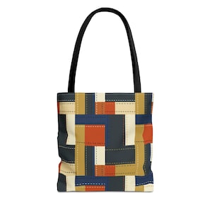 May include: A tote bag featuring a geometric patchwork pattern of rectangular blocks in navy blue, burnt orange, tan, and cream. The design includes dashed lines that mimic stitching between the colored segments and two black shoulder straps.