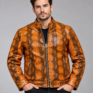 Puede incluir: Una chaqueta de manga larga con un vibrante patrón de piel de serpiente en naranja y negro. La chaqueta tiene un cuello alto, un cierre de cremallera central en tono plateado y dos bolsillos con cremallera en la parte delantera.