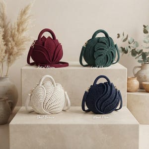 Puede incluir: Cuatro bolsos redondos de ganchillo con asas y correas para el hombro. El bolso burdeos está etiquetado como Petal Bloom, el verde oscuro como Leaf Whisper, el crema como Shell Breeze y el azul marino oscuro como Wave Flow.