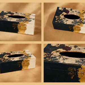 May include: A rectangular tissue box cover featuring a dark navy blue and white surface with a floral pattern, script text, and gold leaf accents. The box includes an oval opening on the top and a small, metallic bronze-coloured latch on the front.