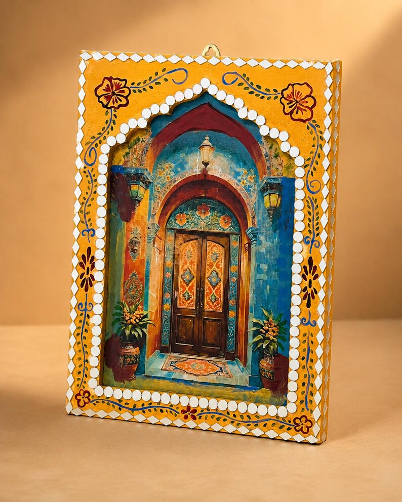 May include: A rectangular wall hanging featuring a painted scene of a wooden double door set within a blue archway. The frame is painted yellow with white diamond-shaped accents and floral motifs, and includes a small metal hook at the top.