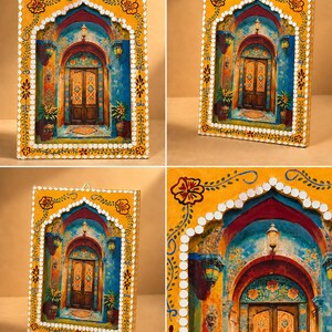May include: A rectangular wall art piece featuring a painted scene of a wooden door set within a blue archway. The frame is yellow with hand-painted floral motifs and small circular mirrors embedded along the inner arched border.