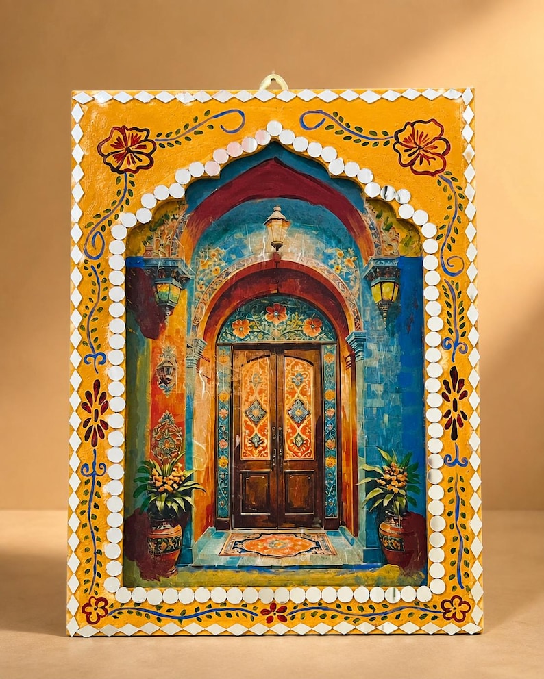 May include: A rectangular wall hanging featuring a painted scene of an arched doorway with double wooden doors, flanked by potted plants. The frame is painted yellow with floral motifs and bordered by small, reflective, diamond-shaped mirrors.