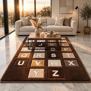 May include: A rectangular area rug featuring a grid of raised square tiles in shades of brown, tan, and cream. Each tile displays a single white letter of the alphabet from A to Z, arranged in sequential order across the surface of the rug.