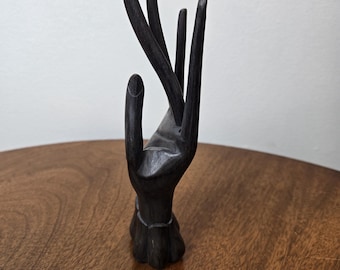 Houten handsculptuur: uitgesneden donkerbruine houten sieradenstandaard.