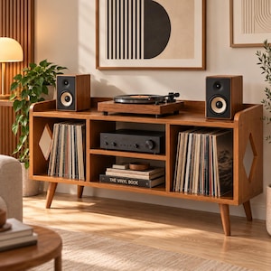 Könnte beinhalten: Ein hölzernes Medienmöbel mit konischen Beinen, zwei Seitenfächern für Schallplatten, einem mittleren Regal mit einem Audio-Receiver sowie einer Oberseite mit Plattenspieler und zwei Lautsprechern. Das Möbelstück hat rautenförmige Ausschnitte.