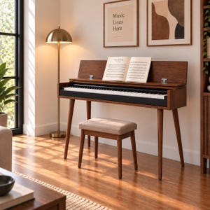 Pode incluir: Um piano digital de madeira escura com teclado preto e um banco a condizer com assento estofado em bege. O piano tem uma tampa articulada que suporta um livro de música aberto com o texto Clair de Lune visível nas páginas, sobre quatro pernas.