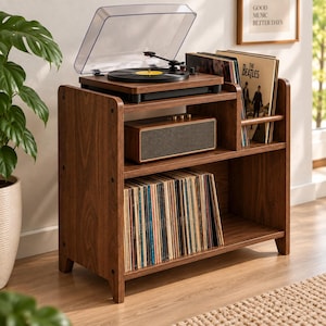 May include: A dark wood record player stand with two shelves. The top shelf holds a turntable with a clear lid and a rectangular speaker. The bottom shelf is filled with vinyl records. A small rack on the top right holds additional records.