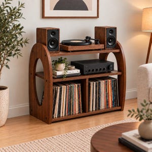 May include: A dark wood media console featuring an arched side design with three horizontal shelves. The top shelf holds two speakers and a turntable. The middle shelf contains an amplifier and books. The bottom shelf stores vinyl records.