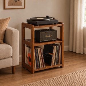 Könnte beinhalten: Ein dreistöckiges Schallplattenregal aus Holz in dunkelbrauner Ausführung. Auf der obersten Ebene steht ein schwarzer Plattenspieler, in der Mitte ein schwarzer Marshall-Lautsprecher und auf der untersten Ebene befinden sich Vinyl-Schallplatten.