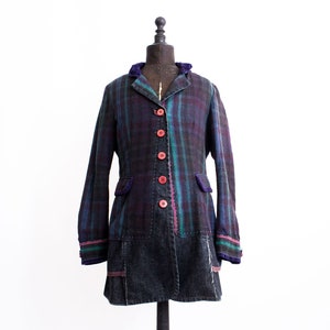 May include: A long-sleeved plaid jacket with a denim skirt overlay. The jacket has a purple, green and black plaid pattern with red buttons. The skirt is a dark denim with a frayed hem.